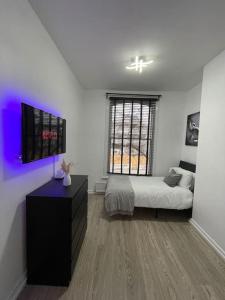 um quarto com uma cama e uma televisão em Spacious, Modern 2 Bed Apartment em Londres