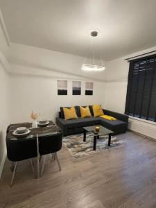 Spacious, Modern 2 Bed Apartment في لندن: غرفة معيشة مع أريكة وطاولة