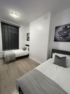 a bedroom with two beds and a window at Spacious, Modern 2 Bed Apartment in London