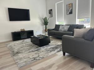 a living room with a couch and a flat screen tv at Atlanta Elegance in Atlanta