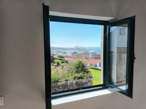 a window with a view of a city at Casa do Lameirinho in Angra do Heroísmo