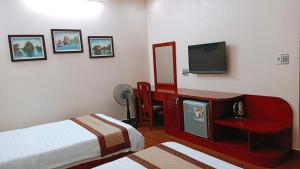 a hotel room with two beds and a television at Paradis Hotel in Ha Long