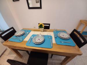 una mesa de madera con alfombras azules y platos en ella en LA SAN JUAN en Zona Norte en San Miguel de Tucumán