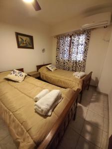 two beds in a room with a window at LA SAN JUAN en Zona Norte in San Miguel de Tucumán