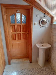 a bathroom with a wooden door and a sink at Detached stone house with access to a large garden near beach in Kemer