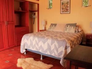 1 dormitorio con 1 cama y armario rojo en Casa Bartzis, Close to Orosi and Tapanti National Park, en Orosí