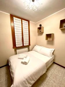 um quarto com uma cama branca e toalhas em La jolie petite maison em Sandra