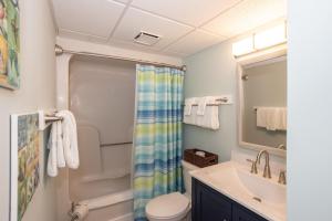 a bathroom with a sink and a toilet and a mirror at 0606 Endless Summer by Atlantic Towers in Carolina Beach