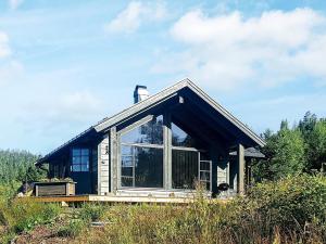 una casa con una gran ventana en una colina en 6 person holiday home in Passebekk-By Traum, en Omholt
