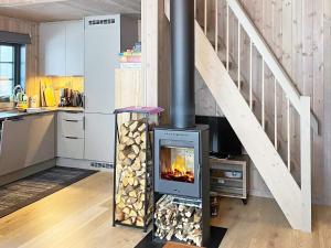 cocina con estufa de leña y escalera en 6 person holiday home in Passebekk-By Traum, en Omholt