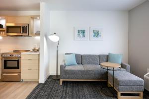 a living room with a couch and a table at TownePlace Suites by Marriott Canton Riverstone Parkway in Canton