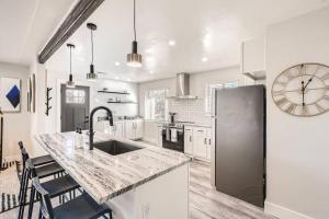 uma cozinha com um balcão, um lavatório e um relógio em NEW Luxurious Modern Space just West of Denver em Wheat Ridge