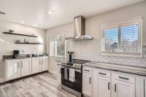 uma cozinha com armários brancos e um forno de fogão preto em NEW Luxurious Modern Space just West of Denver em Wheat Ridge