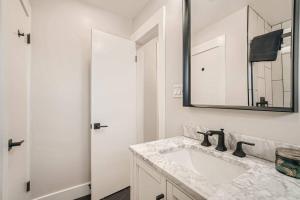a white bathroom with a sink and a mirror at NEW Luxurious Modern Space just West of Denver in Wheat Ridge