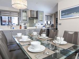 ein Esszimmer mit einem Tisch mit Tellern und Weingläsern in der Unterkunft Harbour Cottage in Dartmouth