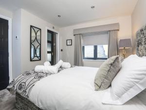 Un dormitorio con una gran cama blanca y una ventana en Harbour Cottage, en Dartmouth