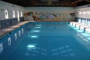a large swimming pool with blue water at Hotel Abbazia in Grado