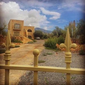 a yellow fence in front of a house at Orion Residence Mani in Agios Nikolaos