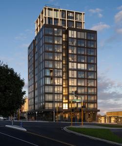 a tall glass building on a city street at Stay Max Apartment for Perfect Short Stay in Auckland