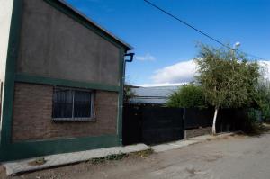 a side of a building with a fence at Los Ñires in Esquel