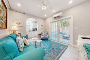 a living room with a blue couch and a kitchen at Julia Whitehead Guest Suites in Key West