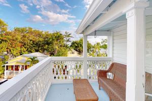um alpendre com dois bancos e um corrimão branco em Julia Whitehead Guest Suites em Key West
