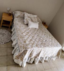 a bed with a white comforter and pillows on it at LA CASA DE LA NONA in Guaymallen