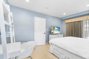 um quarto com uma cama branca e uma televisão em Isle of Venice Residence and Marina em Fort Lauderdale
