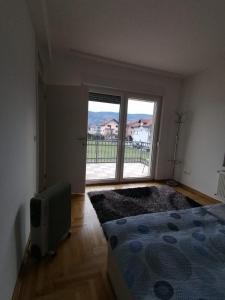 1 dormitorio con cama y ventana grande en Delux Apartment, en Sarajevo