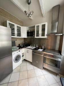 uma cozinha com uma máquina de lavar roupa e uma máquina de lavar roupa em Le Cherche Midi - Appartement centre historique d'Uzès em Uzès