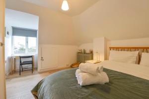 a bedroom with a bed with a chair and a window at 3 Meldrum Close in Dawlish