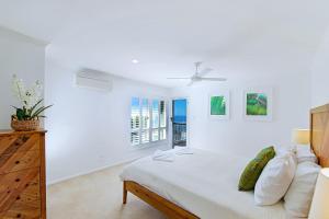 1 dormitorio blanco con 1 cama y ventilador de techo en 10 Mona Vista Court en Coolum Beach