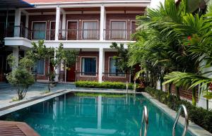 un hotel con piscina frente a un edificio en Tam Coc international friends, en Ninh Binh
