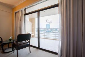 a room with a large window with a view of the city at The Royal River Hotel in Bangkok