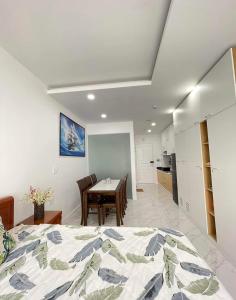 ein Schlafzimmer mit einem Bett und einem Tisch sowie eine Küche in der Unterkunft Ocean Vista - Sealinks in Ấp Chợ Dinh