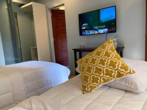 Schlafzimmer mit einem Bett mit einem Kissen und einem TV in der Unterkunft The Great Molave FAMILY ROOM in Cavite