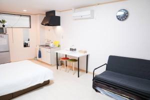 a bedroom with a bed and a small kitchen at 難波南52 in Osaka