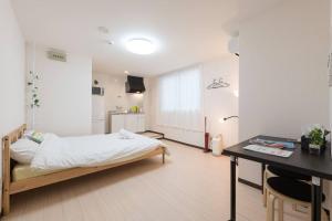 a bedroom with a bed and a desk in it at 難波南52 in Osaka