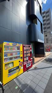 a vending machine on a sidewalk next to a building at 難波南52 in Osaka