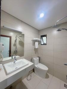 a bathroom with a white toilet and a sink at Rosy Motel Trung Yên in Hanoi