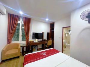 a bedroom with a bed and a desk with a computer at Rosy Motel Trung Yên in Hanoi