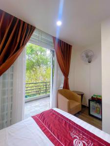 a bedroom with a bed and a window and a chair at Rosy Motel Trung Yên in Hanoi