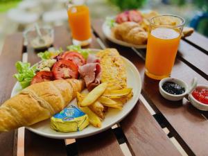 un piatto di prodotti per la colazione su un tavolo con succo d'arancia di Namaste resort a Sam Roi Yot