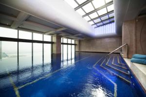 a swimming pool with blue water in a building at The Domain Bahrain Hotel and Spa - Adults Friendly 16 Years Plus in Manama