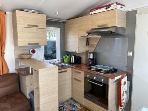 małą kuchnię z drewnianymi szafkami i kuchenką w obiekcie Mobil-home à Fouras : Proche Plage, 2 Chambres, TV, Plancha, Parking, Idéal Famille - FR-1-709-58 w mieście Fouras +6 zdjęć