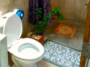 a bathroom with a toilet and a potted plant at Namaste resort in Sam Roi Yot