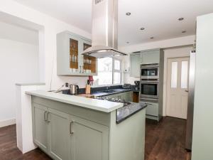 a kitchen with white cabinets and a large counter top at Porthmeor Beach House in St Ives