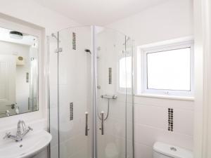 Un baño blanco con ducha y lavabo. en Porthmeor Beach House, en St Ives 37 fotos más