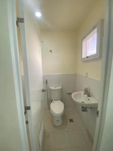 biała łazienka z toaletą i umywalką w obiekcie New 2 Bedroom Home w mieście Cagayan de Oro