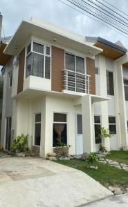 Biały i brązowy dom z balkonem w obiekcie New 2 Bedroom Home w mieście Cagayan de Oro